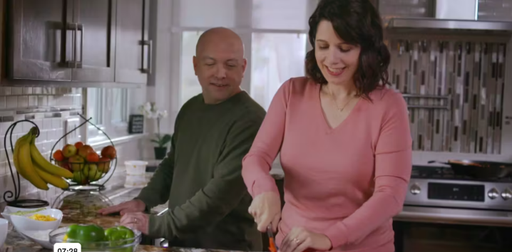Ann preparing food in the kitchen with a companion, featured in her Somatuline® Depot patient story.
